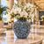 Small deep blue Bouquet De Fleurs ceramic vase styled with white orchids in an elegant hotel lobby setting