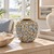 Small moss green floral relief ceramic vase displayed without flowers in a refined coastal interior