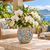 Small moss green ceramic floral vase styled with white orchids in a bright coastal setting