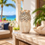 Large cream white artichoke ceramic vase displayed without flowers on a Caribbean veranda with ocean views