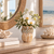 Small cream white artichoke ceramic vase styled with delicate flowers in a bright coastal interior