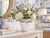Handmade Thai oyster white ceramic vase with light blue lily flowers styled in a blue and white coastal room with botanical wallpaper