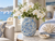 Handmade light blue floral ceramic vase with white hydrangeas styled in a bright sunlit interior
