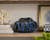 Small indigo blue ceramic bowl planter displayed on a shelf in a refined coastal interior