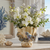 Aqua and cream octopus ceramic vase styled with greenery in an upscale coastal interior.