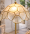 Close-up of the natural Capiz shell dome shade on table lamp L111L showing the layered shell construction and brass-toned framing.