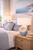 Handmade Thai Santorini blue and white ceramic table lamp styled on a bedside table in a sophisticated coastal bedroom