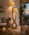 Infinity handwoven abaca rope floor lamp FL183 styled beside coastal seating with its sculptural double-arm silhouette fully visible.