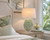 Golden Jasmine Bloom ceramic table lamp displayed beside seating in an elegant soft green coastal interior