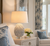 Handmade Thai Blue Jasmine Bloom Ceramic Table Lamp displayed on an accent table in a bright coastal interior.