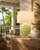 Green and ivory oyster shell ceramic table lamp styled on an accent table in a bright tropical coastal interior
