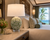 Handmade Thai green ceramic oyster shell table lamp styled beside neutral seating in a coastal room