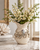 Small cream octopus ceramic vase styled with white flowering branches in an elegant coastal interior.