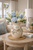 Medium handmade cream octopus ceramic vase styled with delicate flowers in an elegant coastal interior.