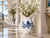 Extra large blue and white octopus ceramic vase with white flowering branches displayed in a grand coastal entryway.