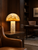 Golden Capiz Shell Mushroom Table Lamp L113S illuminated on a side table in a warm contemporary interior.