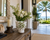 Handmade Thai green floral ceramic vase with white orchids displayed on a coastal entry veranda