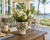 Handmade Thai green floral ceramic vase with white orchids displayed on a tropical coastal lanai