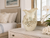 Large cream octopus ceramic vase displayed on a light wood dresser in a serene coastal bedroom.