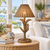 Antique taupe wicker palm table lamp displayed in a bright Florida inspired coastal living room