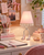 Pink Eve Lamp styled on a creative teen desk with fashion inspired accessories and soft pink decor
