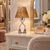 Eve designer table lamp with a leopard skin print shade, clear bead trim, silver legs, and sandal feet on a cream dressing-room vanity.