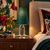 Adam green shade accent lamp illuminated on a wooden side table beside upholstered seating.