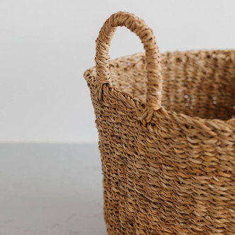 The Harvest round base laundry basket is handcrafted from hogla grass, an aquatic plant. Woven together, it creates a design that's both lightweight and strong, with layers of natural texture and tone.