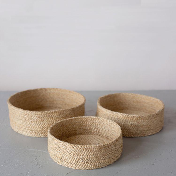 A trio of handwoven natural jute baskets, perfect for storing household items and adding natural texture to your decor.