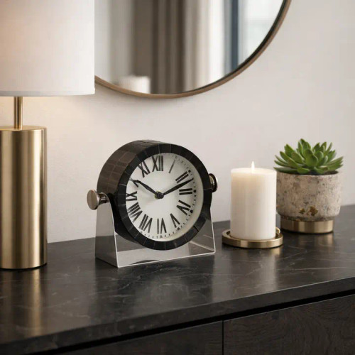 6-inch round table clock featuring a black textured resin frame, classic white dial with bold Roman numerals, and a sleek silver metal swivel stand.