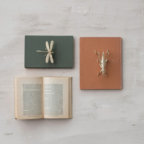 A small pewter dragonfly figurine featuring delicate sculpted wings and a warm metallic gold finish, measuring 4.5 inches long and 3.5 inches wide.