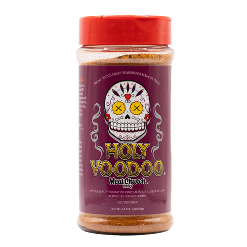 A 12-ounce shaker bottle of Meat Church "Holy Voodoo" seasoning against a white background, featuring a prominent dark purple label with a detailed white sugar skull illustration and a bright red lid.