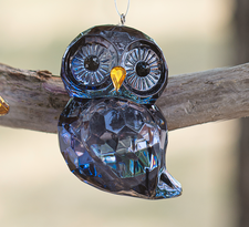 An elegant, clear Cobalt owl ornament with multi-faceted cuts designed to catch and reflect light, featuring a delicate hanging loop for a Christmas tree.