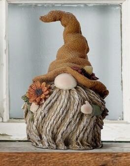 A charming autumn-themed gnome featuring a tall brown fabric hat and holding a vibrant yellow harvest sunflower.