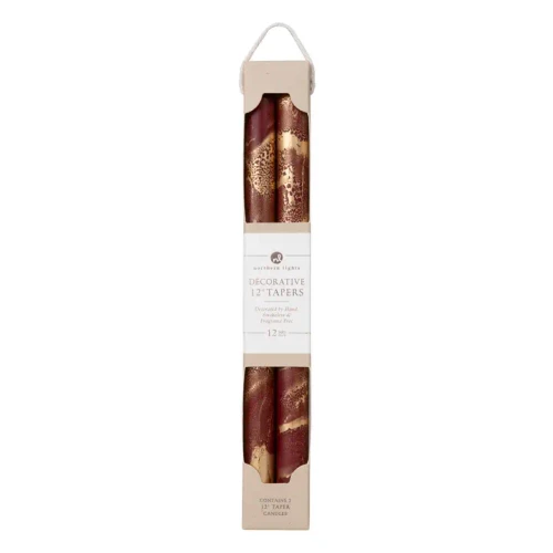 A pair of tall, elegant 12-inch taper candles featuring a smooth cream wax body accented with a shimmering metallic gold brushed finish along the lower portion. The candles stand slender and refined, ideal for traditional candlesticks or holiday centerpiece displays.