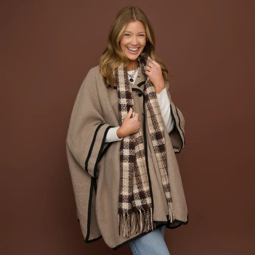 Model wearing a cozy taupe classic plaid fringe scarf layered over a winter coat.