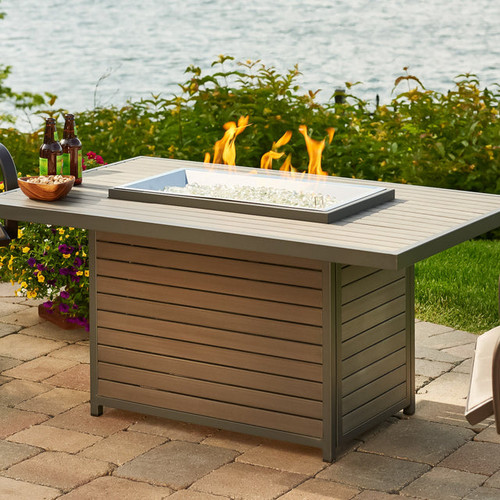 The  Brooks Rectangular Gas Fire Pit Table in Taupe featuring a modern composite decking top and base with a Graphite Grey aluminum frame.