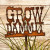 Close-up of rusted metal "Grow Dammit" garden stake in a green plant.