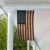 Vintage tea stained American porch flag with a distressed antique finish hanging from a white front porch, creating a classic rustic Americana display.