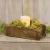 Rustic weathered wooden brick mold box with iron hardware accents, shown holding a pillar candle and green foliage.