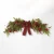 Lush artificial Christmas pine swag adorned with realistic red berries and natural pinecones for holiday door or mantel decor.