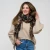 Model wearing a cozy chocolate brown classic plaid fringe scarf layered over a winter coat.
