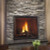 Front view of a Heat & Glo TRUE 36-inch direct vent natural gas fireplace showcasing high-definition logs and dynamic flames against a Tranquil Greige Herringbone brick interior lining.