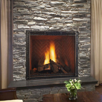 Front view of a Heat & Glo TRUE 36-inch direct vent natural gas fireplace showcasing high-definition logs and dynamic flames against a Tranquil Greige Herringbone brick interior lining.
