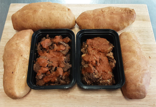 Two containers of meat on a table with bread