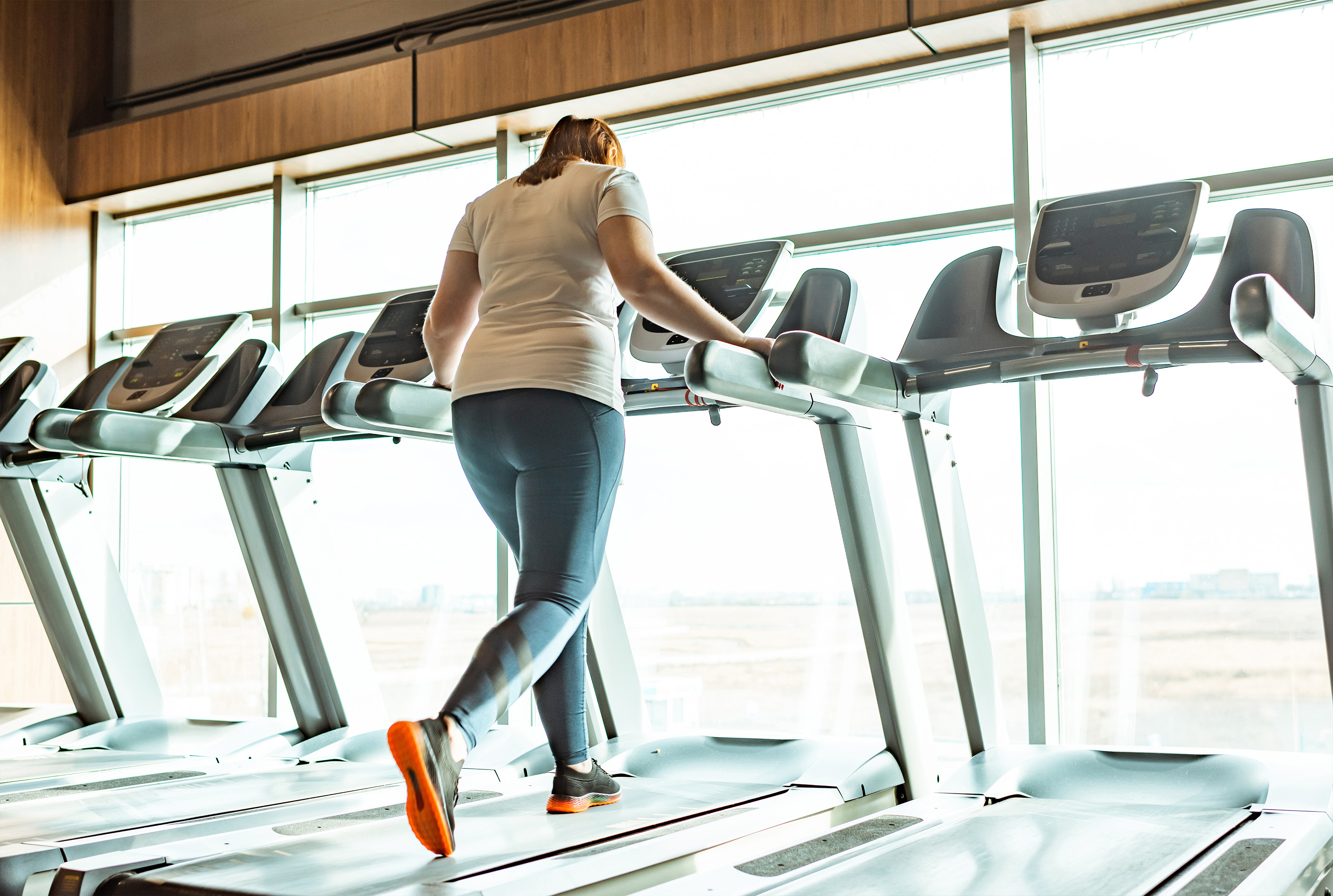 Young woman walking on a treadmill