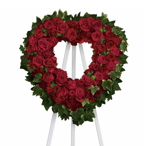 Red roses and carnations make up this beautiful heart shaped stand.