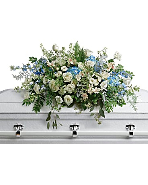 As soft and delicate as a tender remembrance, this stunning spray of sky blue hydrangea and pure white roses brings a fresh, natural beauty to the casket.