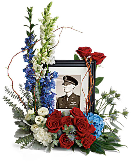 Honor the memory of an always-beloved with this beautiful display bouquet. Designed to surround a favorite photo, its patriotic mix of blue hydrangea with red and white roses is a respectful tribute. *Photo frame not included.