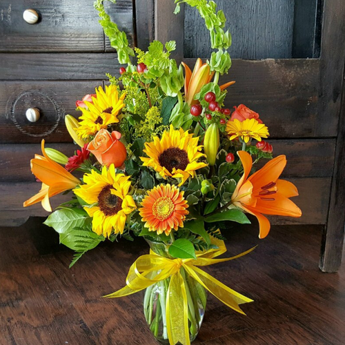 This arrangement radiates as bright as the sun. It's hand-designed with sunflowers, roses, gerbera daisies, tiger lilies and belles of Ireland.